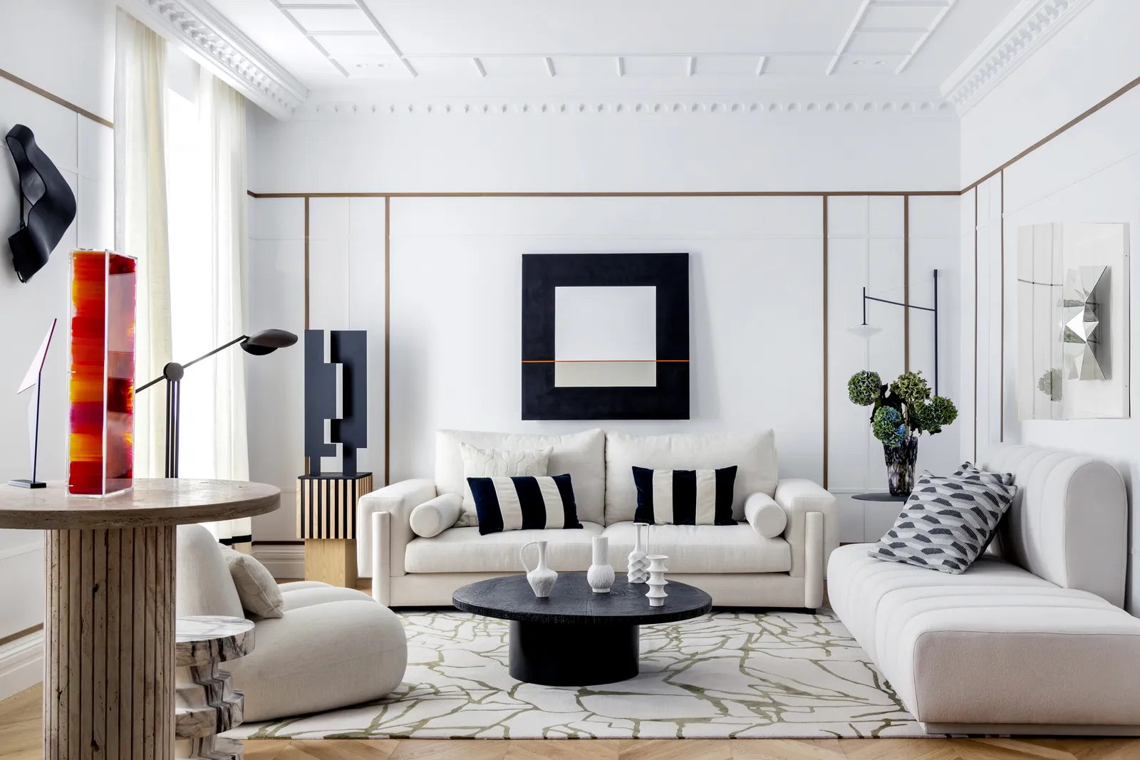 Salón clásico renovado con molduras y arte contemporáneo en una vivienda de Madrid